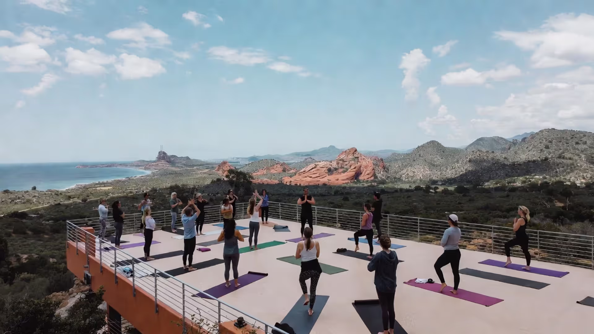 Outdoor yoga class at a retreat center with a natural landscape in the background.