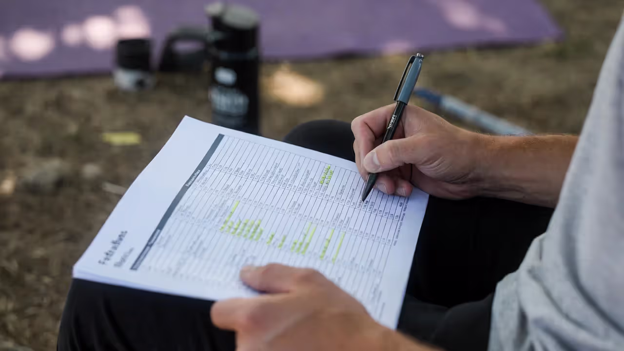 Attendee planning yoga festival schedule using printed program.