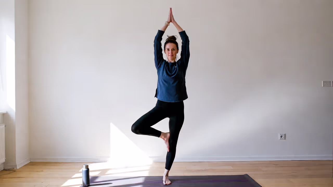 Person holding Tree Pose with a water bottle nearby